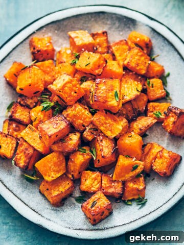 Air fryer butternut squash with thyme on blue plate.