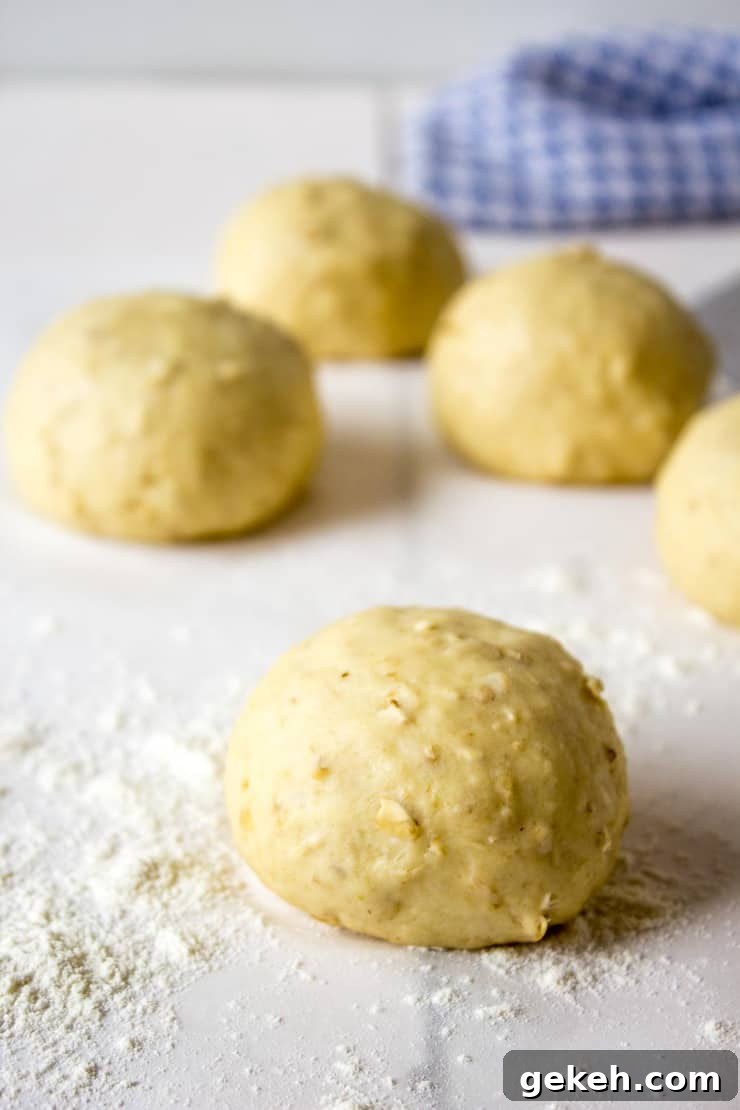 Soft Oatmeal Dinner Rolls Recipe for Fluffy Homemade Rolls 3 Balls of dough on board with flour.