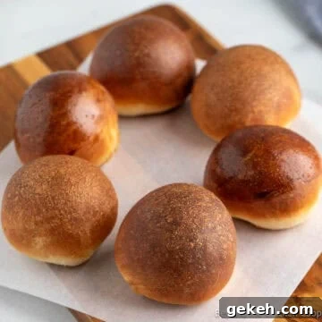 A circle of round dinner rolls each with a different finished glaze.