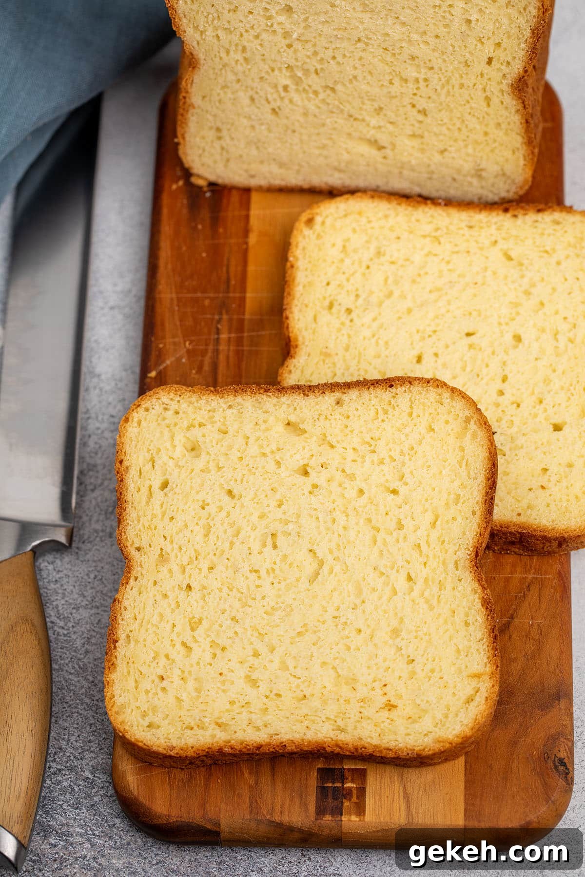 2 individual slices of sandwich bread on brown cutting board on gray surface