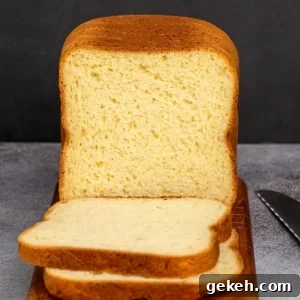 Yellow sliced bread with brown crust on brown cutting board