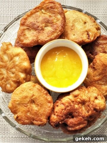 A plate of banana fritters surrounding a bowl of lemon caramel dipping sauce.