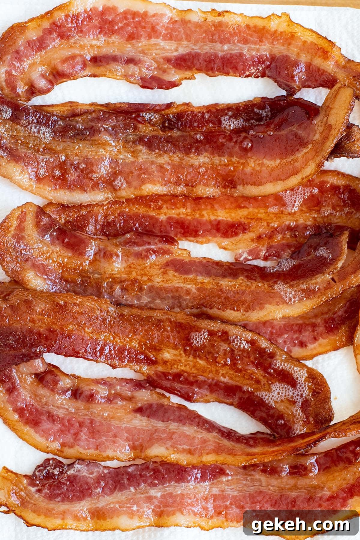 Perfectly Crispy Oven-Baked Bacon: Simple Sheet-Pan Method 6 Fully cooked golden bacon draining on a paper towel.