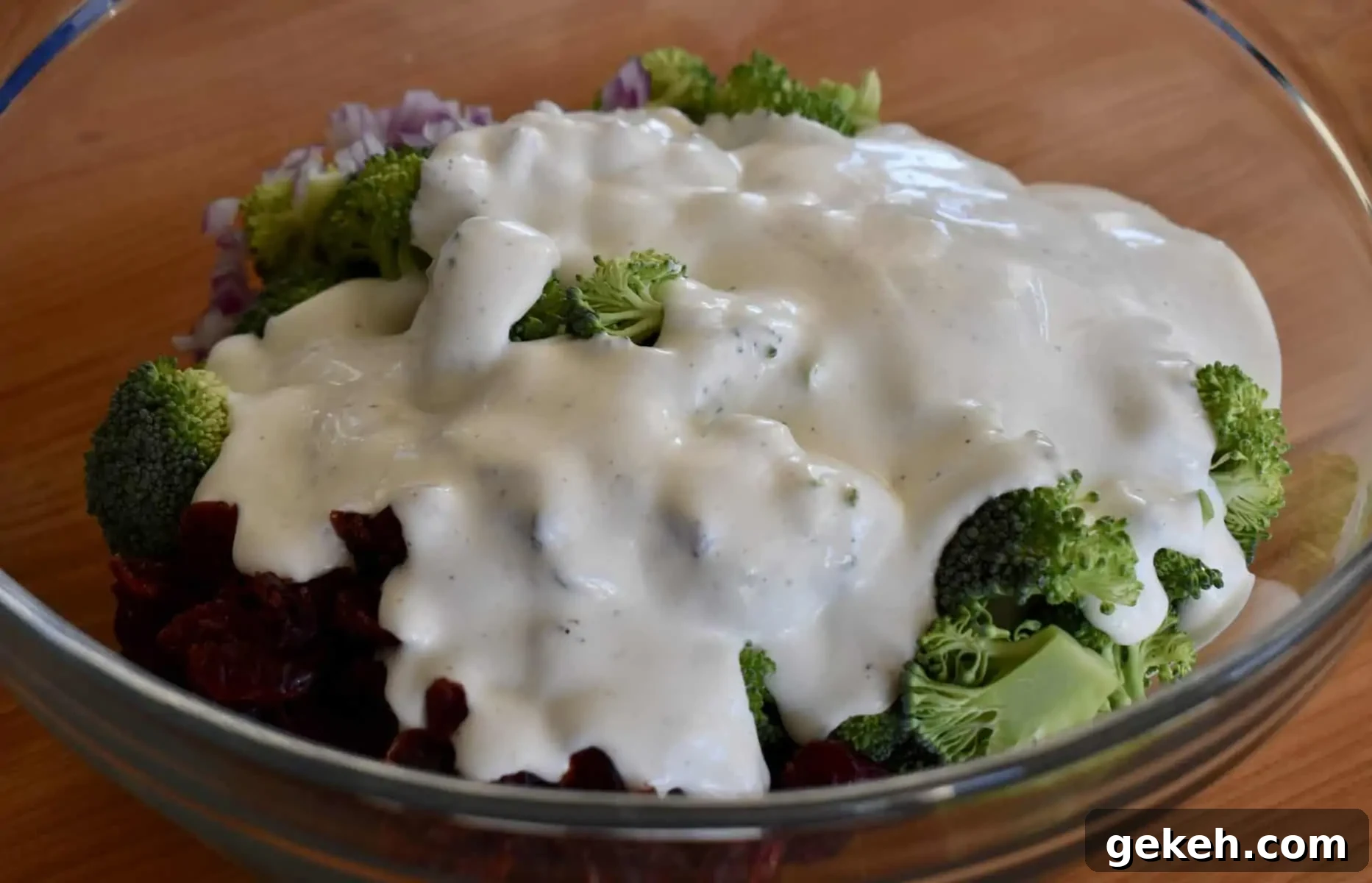 Broccoli and Cranberry Salad with Creamy Greek Yogurt Dressing 6 greek yogurt dressing poured over broccoli cranberry salad in a large glass bowl.
