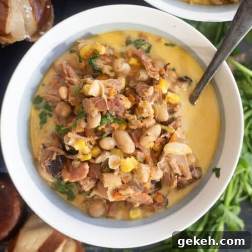 Creamy ham white bean soup in rustic bowl with parsley garnish and crusty bread