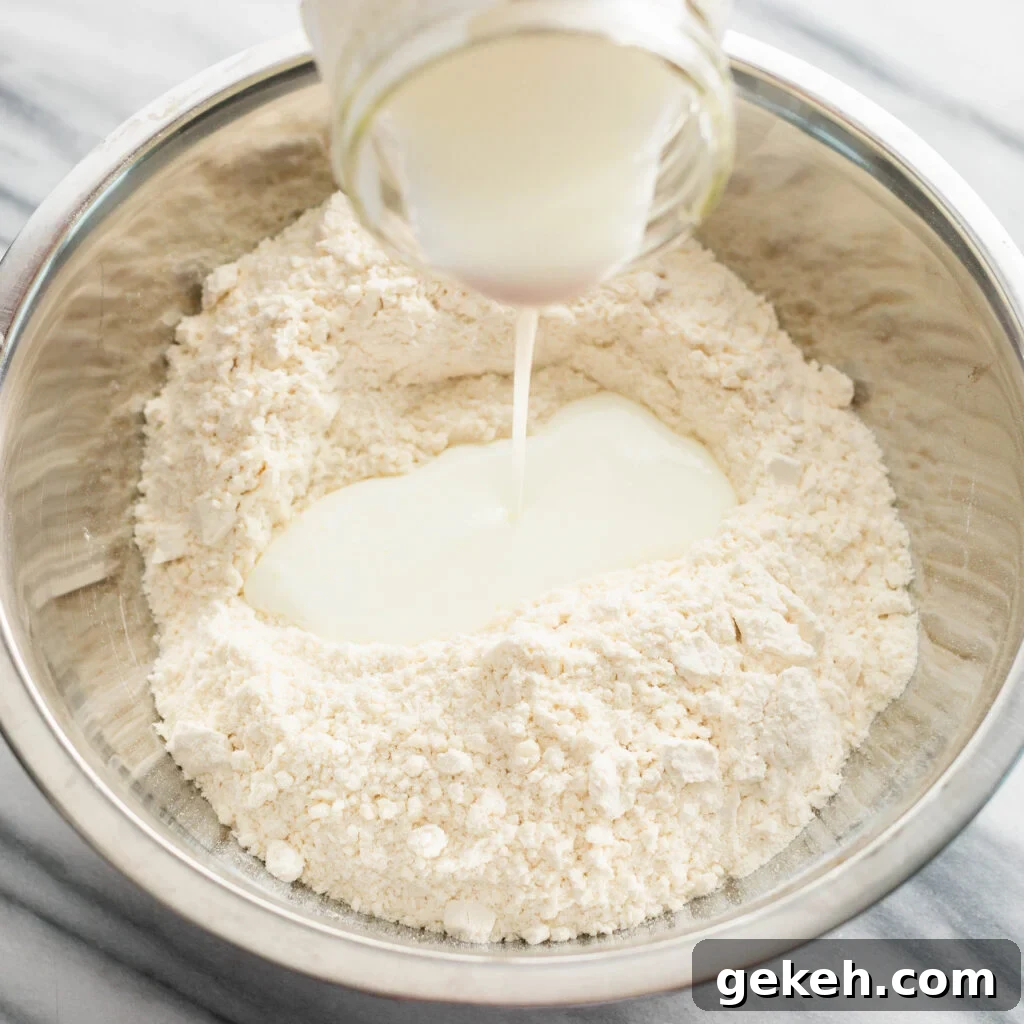 pouring cold buttermilk into a mixing bowl with dry ingredients. 