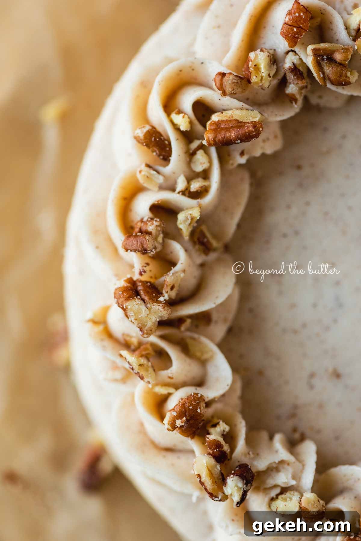 Detailed closeup image of frosted 6 inch carrot cake on sheets of brown parchment paper | All Images © Beyond the Butter®