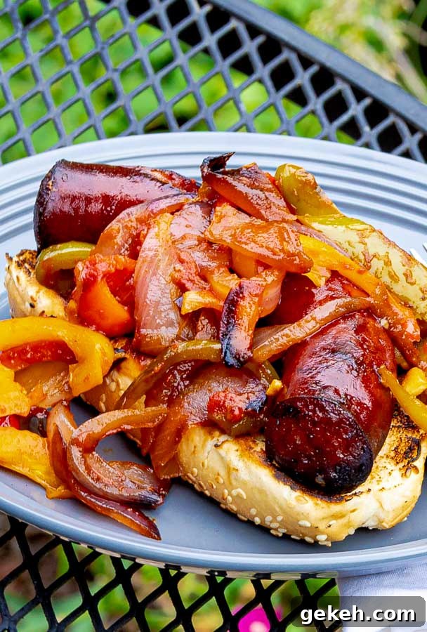 Grilled Sausage with Peppers and Onions on a bun on a gray plate