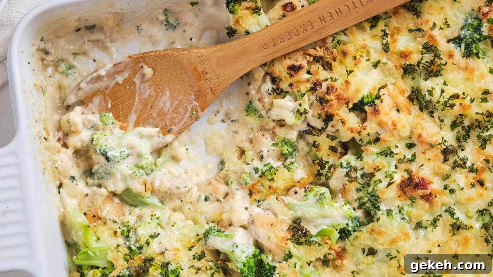 15 Sophisticated Dinner Ideas to Impress with Minimal Effort 6 A fork with a piece of chicken broccoli Alfredo casserole on a white plate.