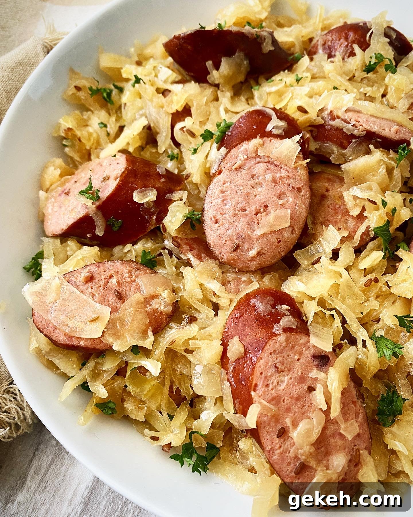 Slow Cooker Sausage with Sauerkraut: Simple Comfort Meal 8 close up side view of Sausage & Sauerkraut in a white bowl