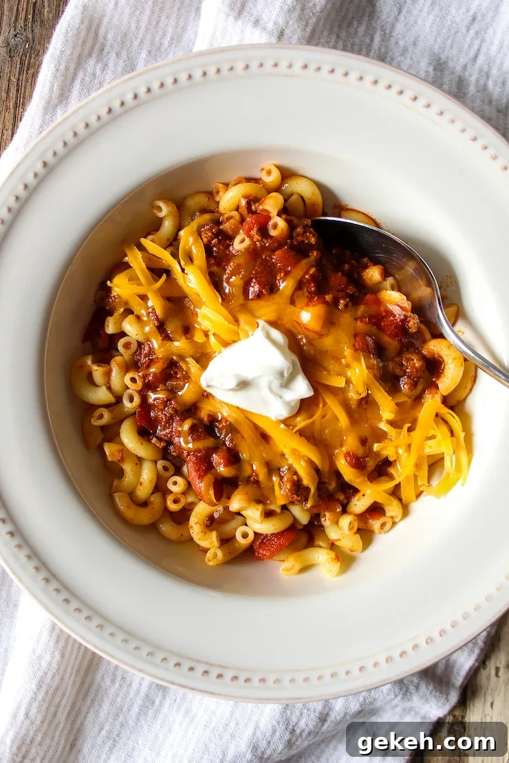 Chili Mac Recipe: Classic Comfort Pasta with Savory Beef and Beans 6 Bowl of chili over macaroni with toppings.