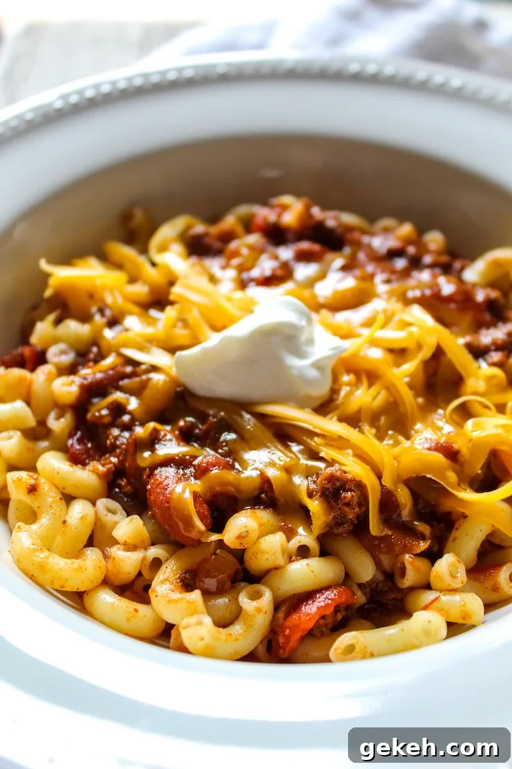 Chili Mac Recipe: Classic Comfort Pasta with Savory Beef and Beans 4 Close up of chili in serving bowl with toppings.