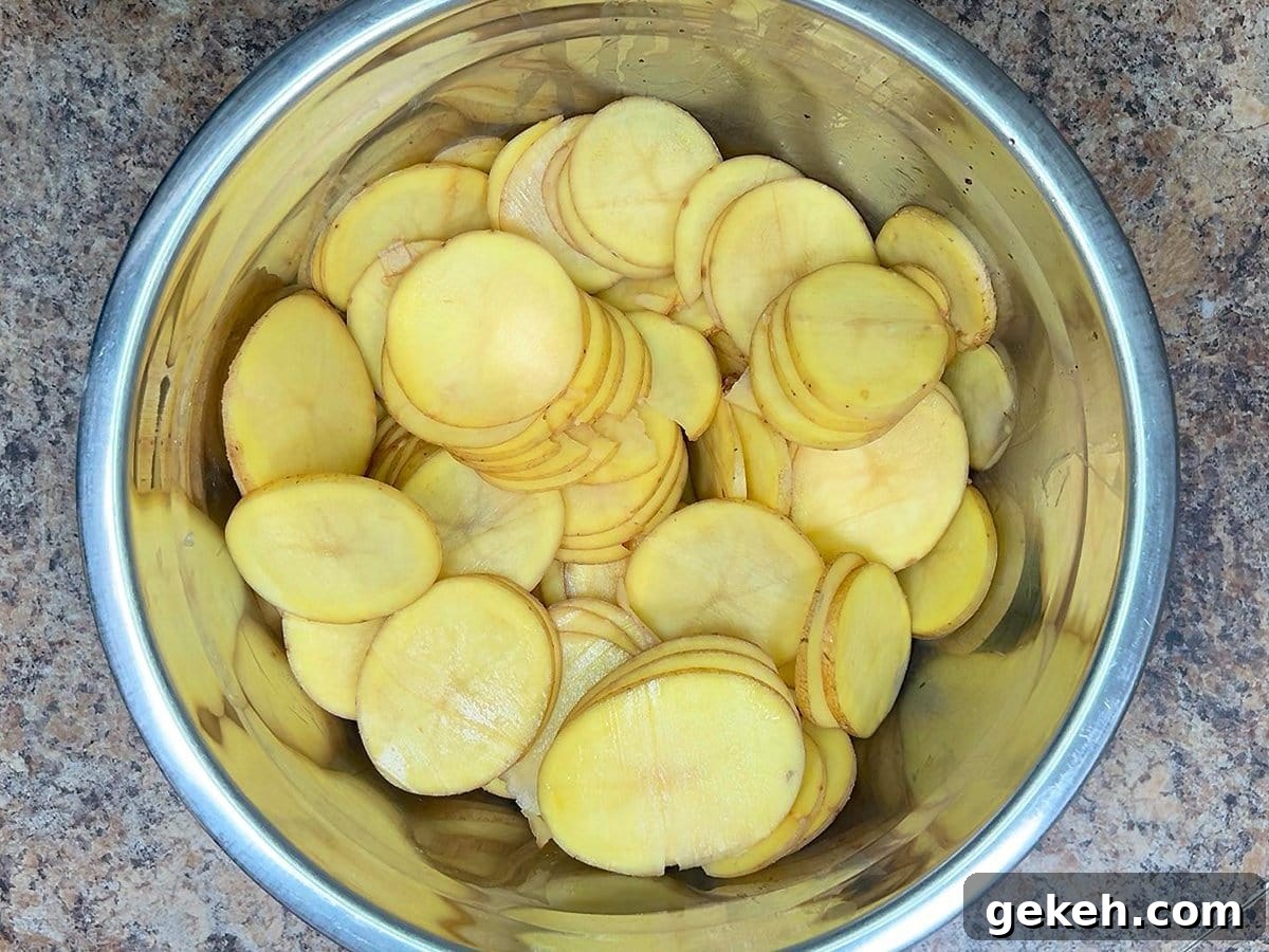 Creamy Scalloped Potatoes with Crispy Bacon 13 Sliced potatoes in a large mixing bowl.