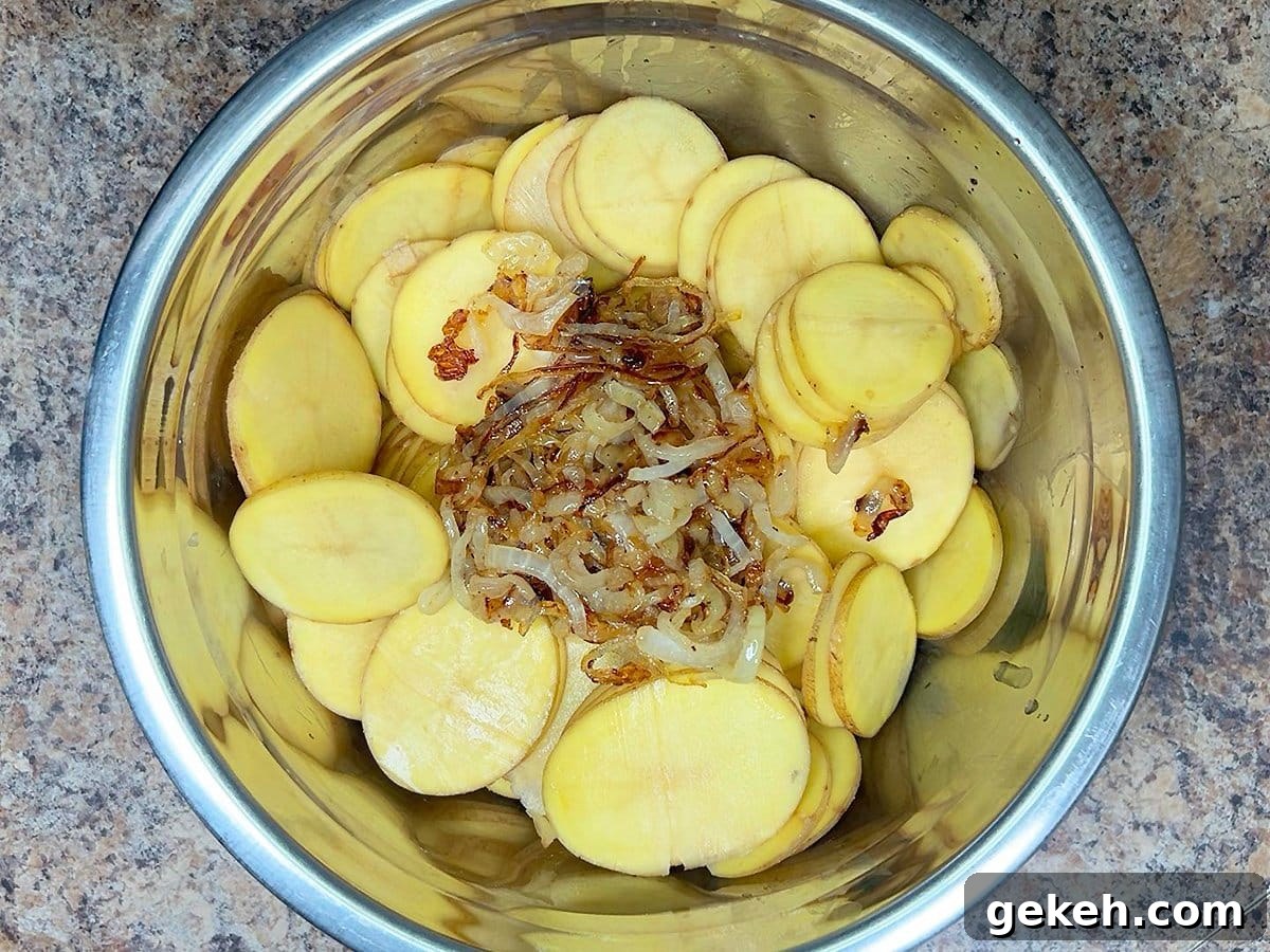 Creamy Scalloped Potatoes with Crispy Bacon 14 Sliced potatoes and caramelized onions in a large mixing bowl.