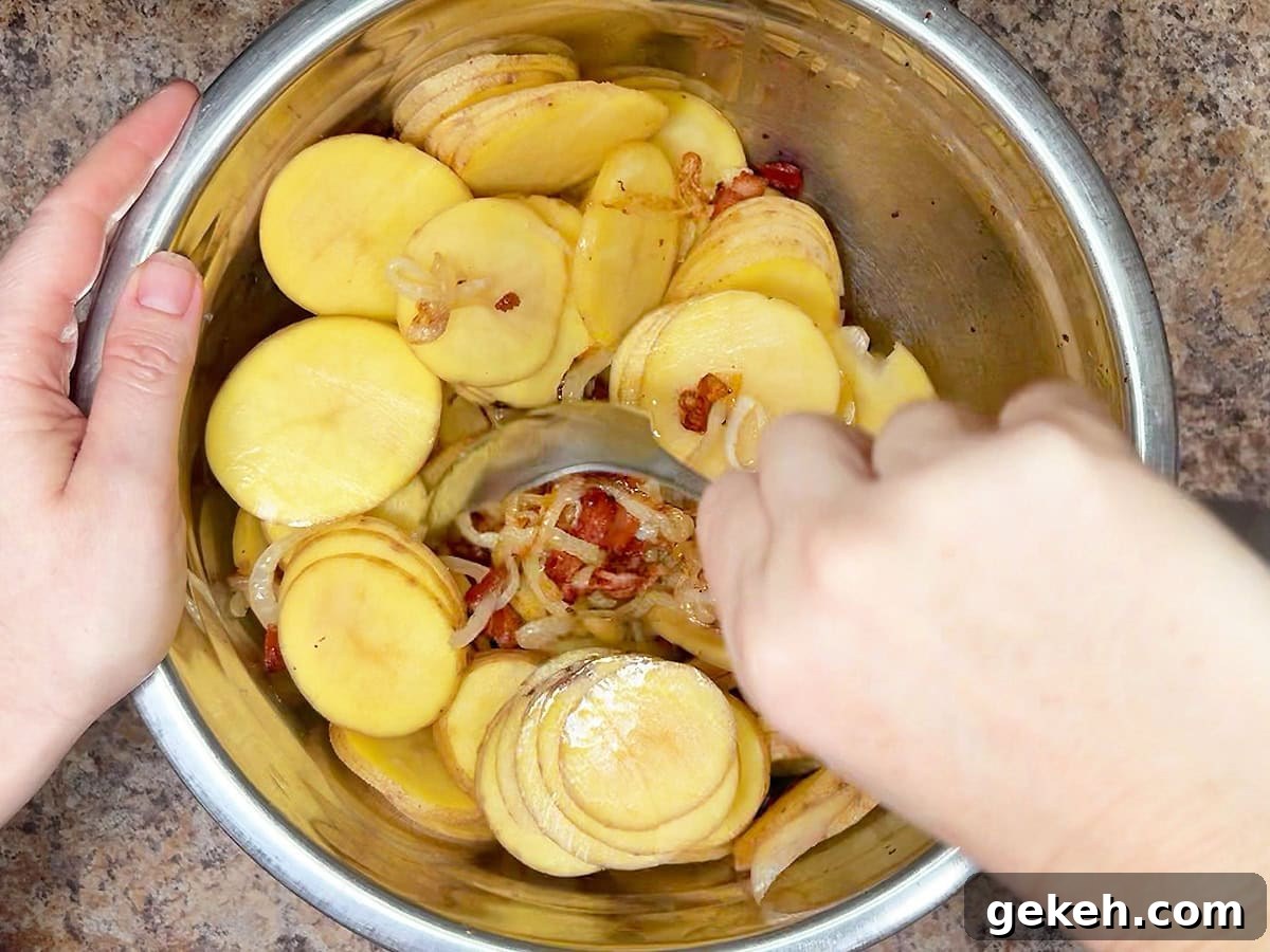 Creamy Scalloped Potatoes with Crispy Bacon 16 Mixing together the sliced potatoes, onions and cooked bacon in a metal mixing bowl.