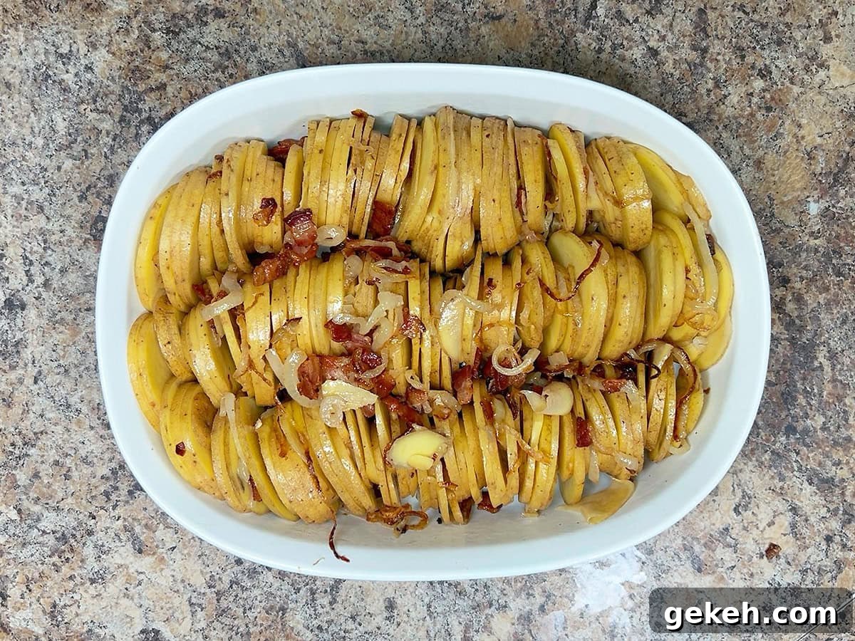 Creamy Scalloped Potatoes with Crispy Bacon 18 Thinly sliced potatoes, bacon, and onions arranged in an oval casserole dish.