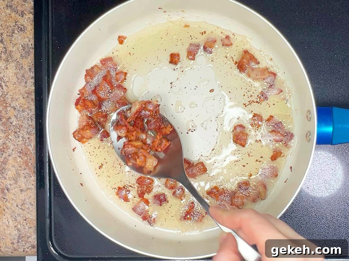 Creamy Scalloped Potatoes with Crispy Bacon 5 Removing the cooked bacon from the skillet with a slotted spoon.