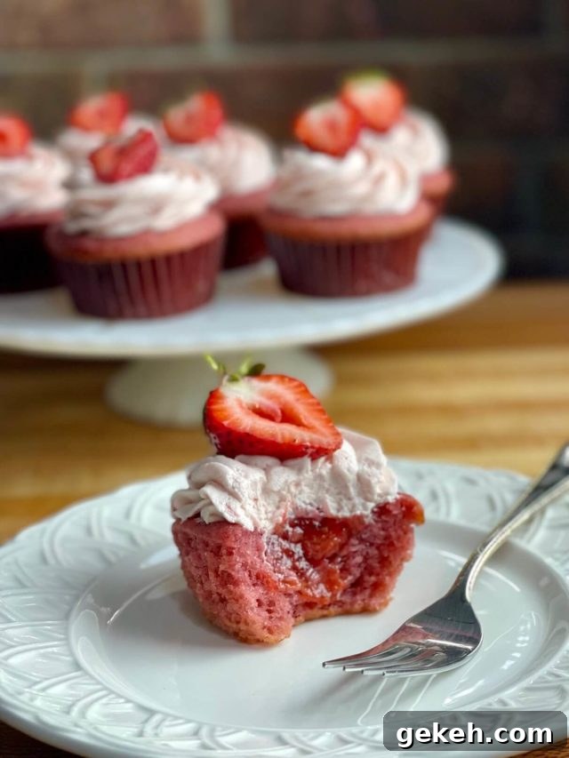 Bakery-Style Strawberry Buttercream Frosting Recipe 4 strawberry cupcakes with fresh strawberry cupcake filling and strawberry frosting on top.