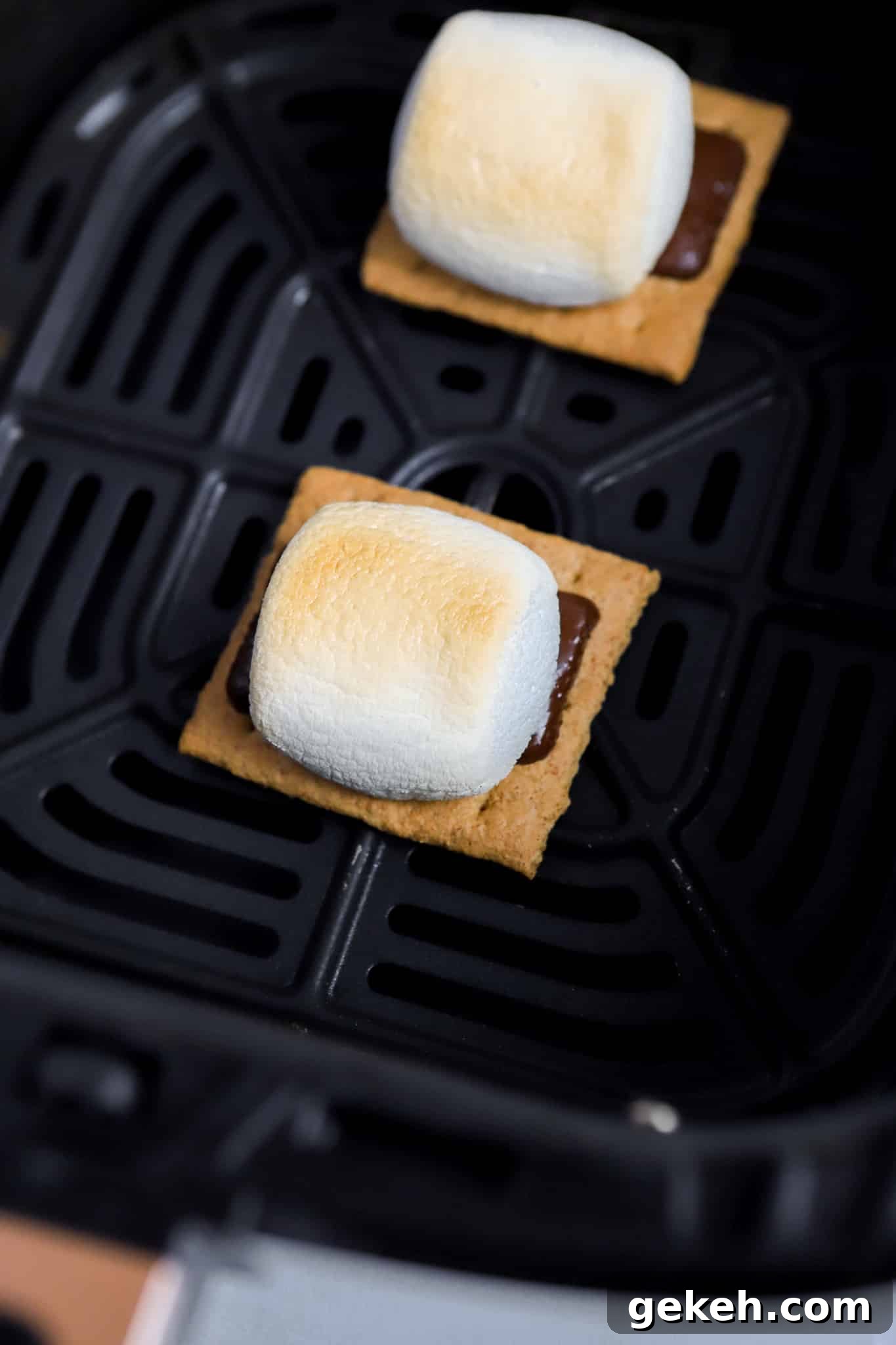 Air Fryer S'mores Recipe: Quick, Crispy S'mores in Minutes 4 graham cracker and dark chocolate and regular marshmallow stacked on top of eachother in air fryer basket
